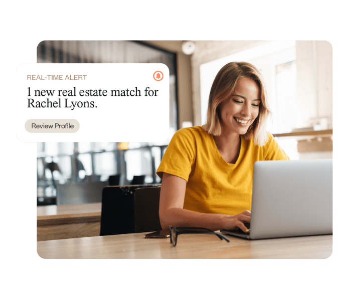 A woman laughing while using her laptop.